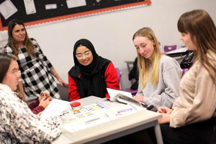 A group of women playing a board game

Description automatically generated with medium confidence